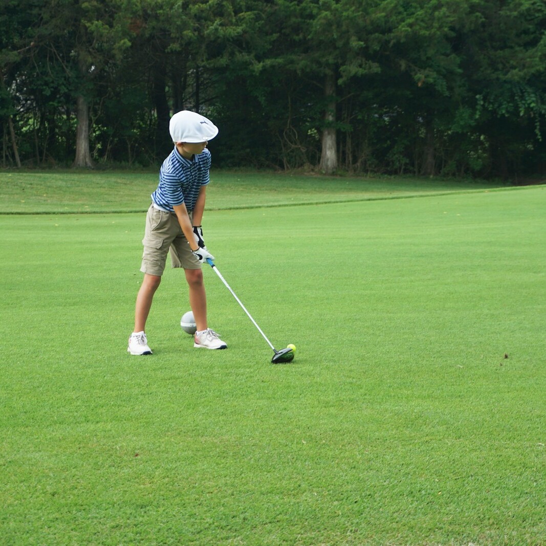 a man is playing golf on a green field