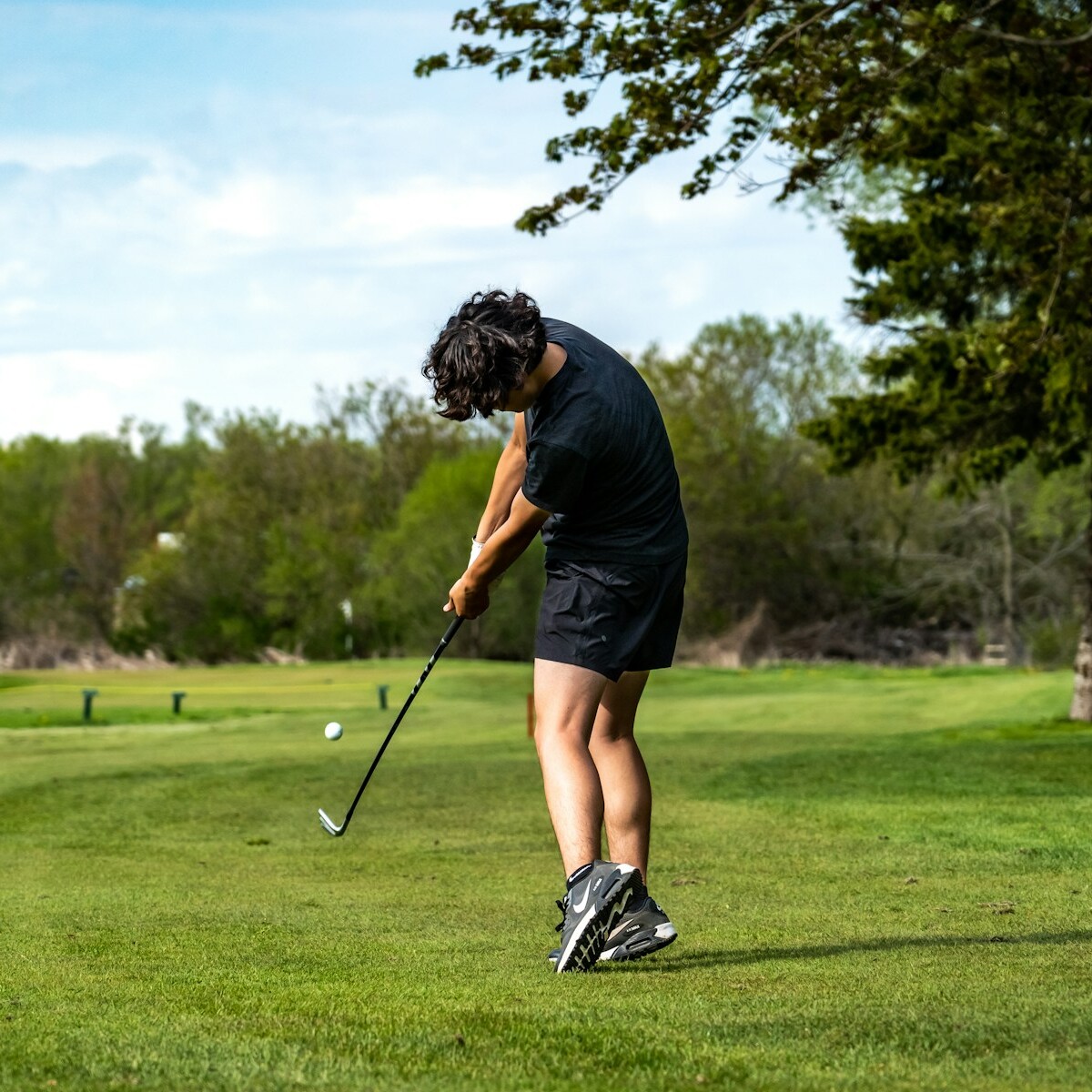 a woman is playing golf on a sunny day